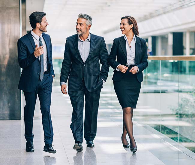 Successful business team walking in a hallway talking to each other