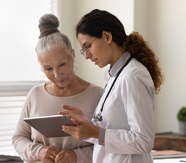 doctor showing tablet screen female patient, explaining electronic prescription